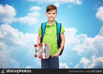 childhood, leisure, school and people concept - happy smiling student boy with backpack and skateboard over blue sky and clouds background