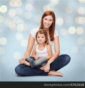 childhood, motherhood, parenting and relationship concept - happy mother with adorable little girl over holidays lights background