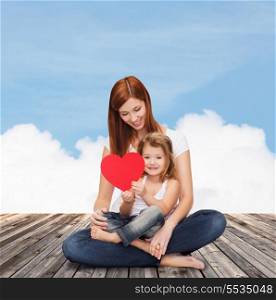 childhood, parenting and relationship concept - happy mother with adorable little girl and red heart