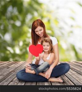 childhood, parenting and relationship concept - happy mother with adorable little girl and red heart