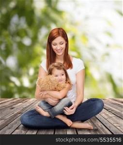 childhood, parenting and relationship concept - happy mother with adorable little girl and teddy bear