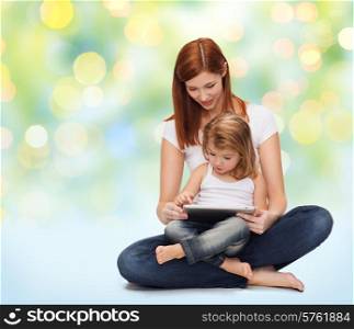 childhood, parenting and technology concept - happy mother with adorable little girl and tablet pc computer over green lights background
