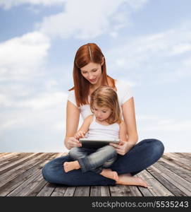 childhood, parenting and technology concept - happy mother with adorable little girl and tablet pc computer
