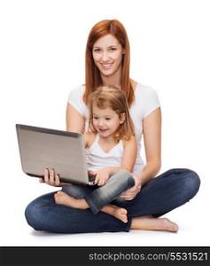 childhood, parenting and technology concept - happy mother with adorable little girl with laptop