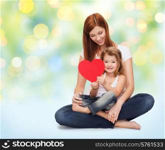 childhood, parenting, people and love concept - happy mother with adorable little girl holding red heart over green lights background