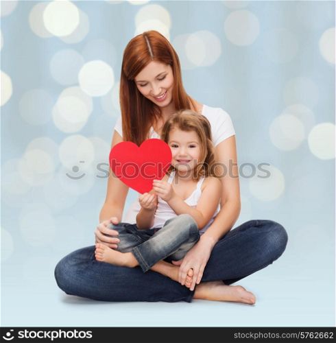childhood, parenting, people and love concept - happy mother with adorable little girl holding red heart over holidays lights background