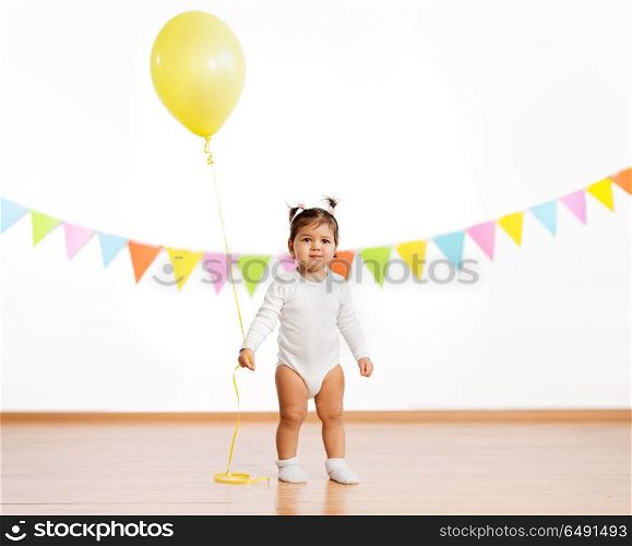 childhood, people and celebration concept - baby girl with helium balloons on birthday party. baby girl with balloons on birthday party. baby girl with balloons on birthday party