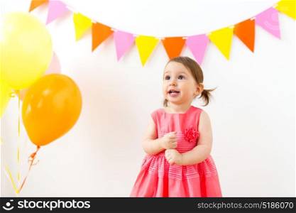 childhood, people and celebration concept - happy baby girl on birthday party. happy baby girl on birthday party