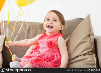 childhood, people and celebration concept - happy baby girl on birthday party at home. happy baby girl on birthday party at home