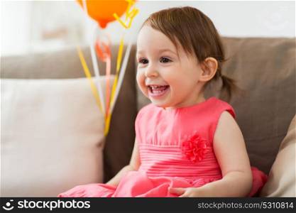 childhood, people and celebration concept - happy baby girl on birthday party at home. happy baby girl on birthday party at home