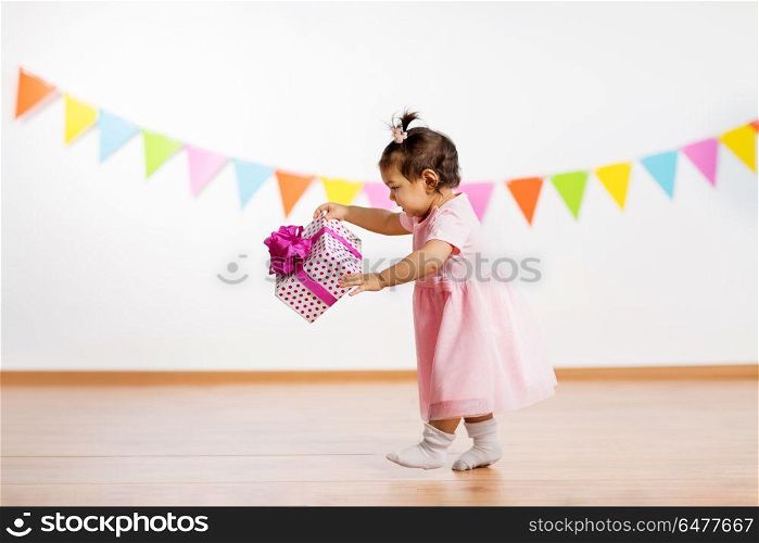 childhood, people and celebration concept - happy baby girl with gift box on birthday party. happy baby girl with gift box on birthday party. happy baby girl with gift box on birthday party
