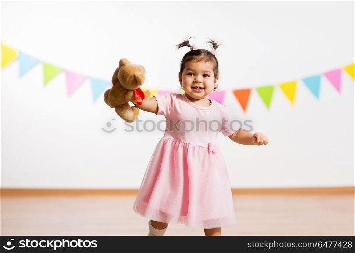childhood, people and celebration concept - happy baby girl with teddy bear toy on birthday party. happy baby girl with teddy bear on birthday party. happy baby girl with teddy bear on birthday party