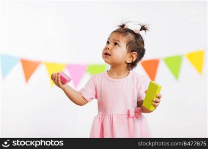 childhood, people and celebration concept - happy baby girl with toy blocks at birthday party. happy baby girl with toy blocks at birthday party. happy baby girl with toy blocks at birthday party