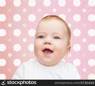 childhood, people and happiness concept - smiling baby girl face over pink and white polka dots pattern background