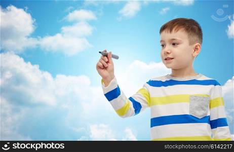 childhood, preschool education, creativity, learning and people concept - happy little girl drawing or writing something with marker over blue sky and clouds background