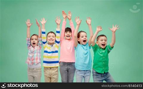 childhood, preschool education, gesture and people concept - happy smiling friends raising fists and celebrating victory over green school chalk board background