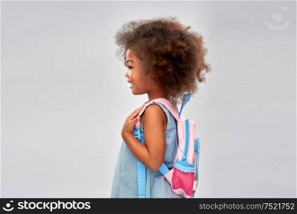 childhood, school and education concept - happy little african american girl with backpack over grey background. happy little african american girl with backpack
