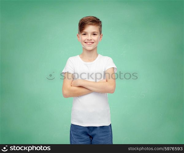 childhood, school, education, advertisement and people concept - happy boy in white t-shirt and jeans over green chalk board background