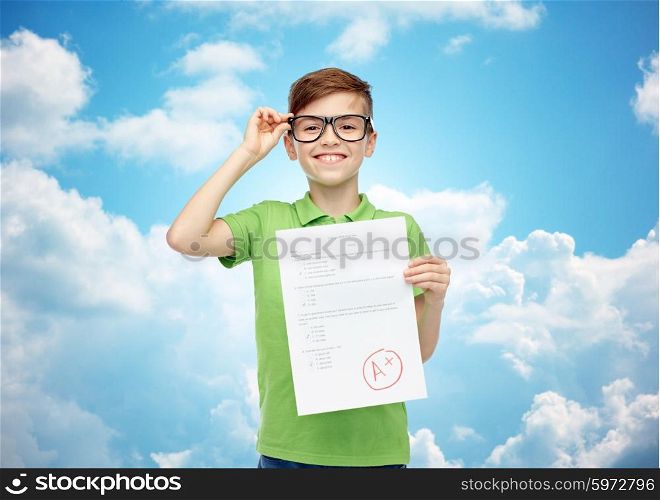 childhood, school, education and people concept - happy smiling boy in eyeglasses holding paper with test result over blue sky and clouds background