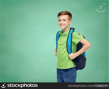 childhood, school, education and people concept - happy smiling student boy with school bag over green school chalk board background