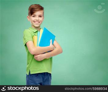 childhood, school, education and people concept - happy smiling student boy with folders and notebooks over green school chalk board background