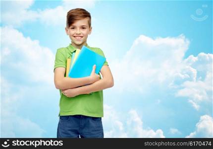 childhood, school, education and people concept - happy smiling student boy with folders and notebooks over blue sky and clouds background
