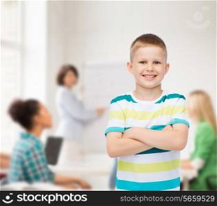 childhood, school, education and people concept - smiling little boy in casual clothes with crossed arms over group of students in classroom