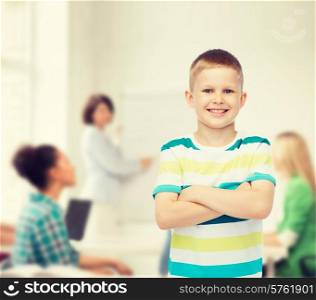 childhood, school, education and people concept - smiling little boy in casual clothes with crossed arms over group of students in classroom
