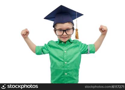 childhood, school, education, knowledge and people concept - happy boy in bachelor hat or mortarboard and eyeglasses showing strong hands