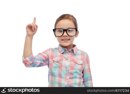 childhood, school, education, vision and people concept - happy little girl in eyeglasses pointing finger up