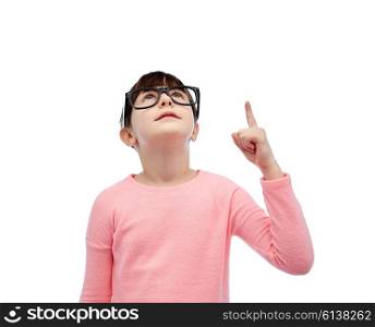 childhood, school, education, vision and people concept - happy little girl in eyeglasses pointing finger up