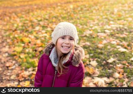childhood, season and people concept - happy beautiful little girl at autumn park. happy beautiful little girl at autumn park. happy beautiful little girl at autumn park