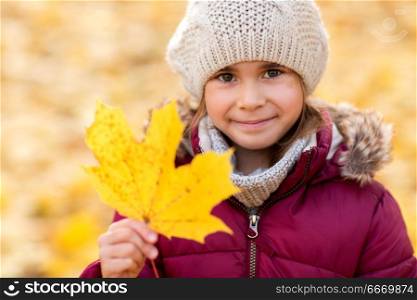 childhood, season and people concept - happy little girl with fallen maple leaf at autumn park. happy girl with fallen maple leaf at autumn park. happy girl with fallen maple leaf at autumn park