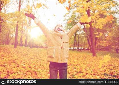 childhood, season and people concept - smiling little girl having fun in autumn park