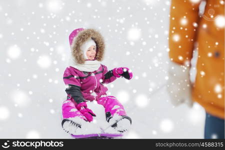 childhood, sledding, fashion, season and people concept - happy little kid on sled outdoors in winter