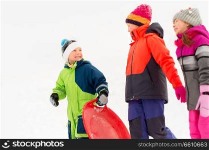 childhood, sledging and season concept - group of happy little kids with sleds in winter. happy little kids with sleds in winter