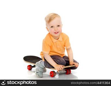 childhood, sport, leisure and people concept - happy little boy sitting on skateboard