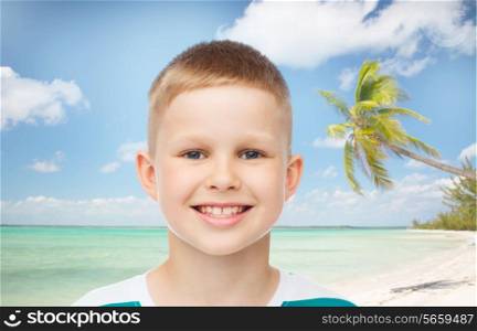 childhood, summer, travel, vacation and people concept - smiling little boy over beach background