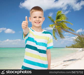 childhood, summer vacation, travel, gesture and people concept - smiling little boy showing thumbs up over tropical beach background