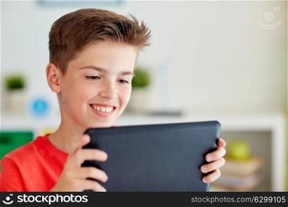 childhood, technology and people concept - close up of smiling boy with tablet pc computer at home. close up of boy with tablet pc computer at home