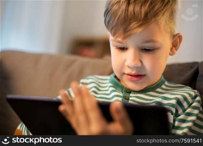 childhood, technology and people concept - happy little boy with tablet pc computer at home. happy little boy with tablet computer at home
