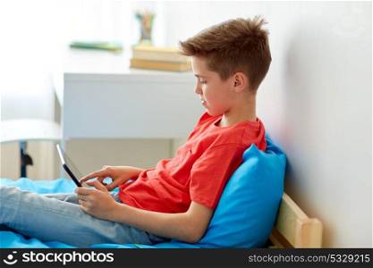 childhood, technology and people concept - smiling boy with tablet pc computer at home. smiling boy with tablet pc computer at home