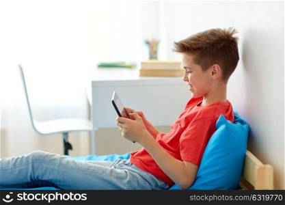 childhood, technology and people concept - smiling boy with tablet pc computer at home. smiling boy with tablet pc computer at home
