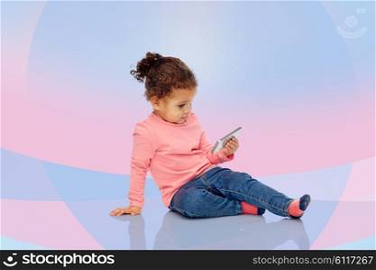 childhood, technology and people concept - smiling little african american baby girl playing with smartphone and sitting on floor over pink and violet background