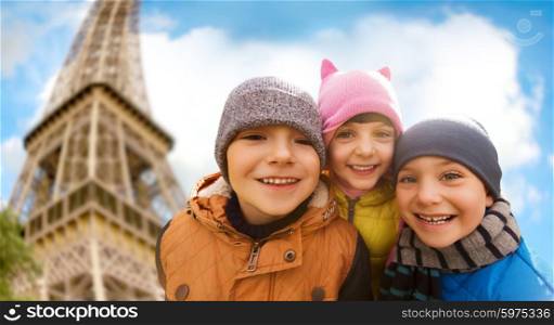 childhood, tourism, travel, vacation and people concept - group of happy kids over eiffel tower and sky background