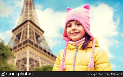 childhood, tourism, travel, vacation and people concept - happy beautiful little girl over eiffel tower in paris background