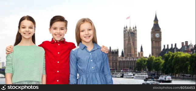 childhood, travel, tourism, friendship and people concept - happy smiling boy and girls hugging over london city background