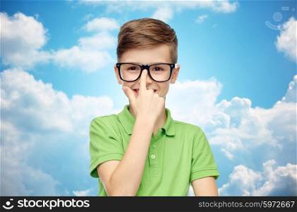 childhood, vision, school, education and people concept - happy smiling boy in green polo t-shirt in eyeglasses over blue sky and clouds background