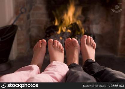Children&acute;s feet warming at a fireplace