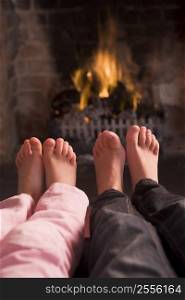 Children&acute;s feet warming at a fireplace
